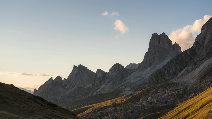Clouds around over the peak of a tall mountain in a range