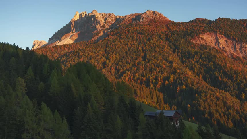 Landscape of an isolated wooden house on a mountain with vegetation and dusk