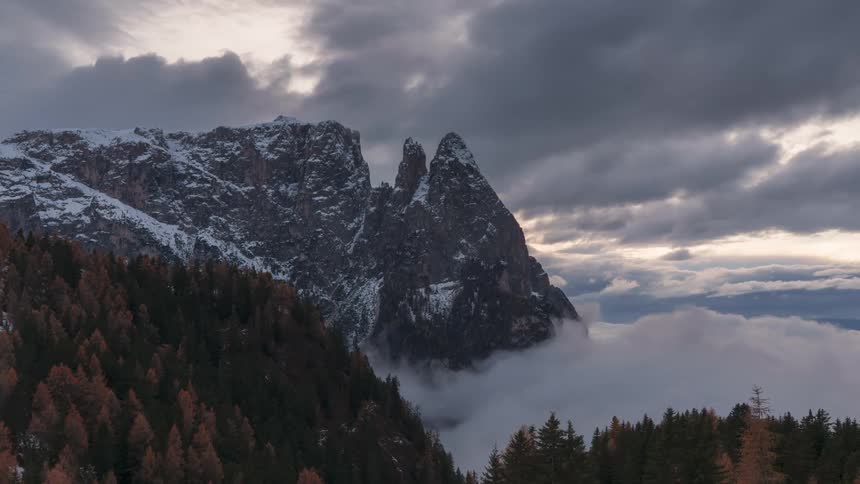 The rugged snow capped peak pierces through the clouds