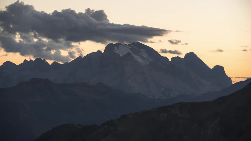Mountainous landscape at dusk with cloudy sky