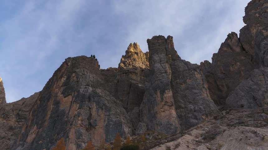 Rocky mountains with cliffs against a blue sky with clouds