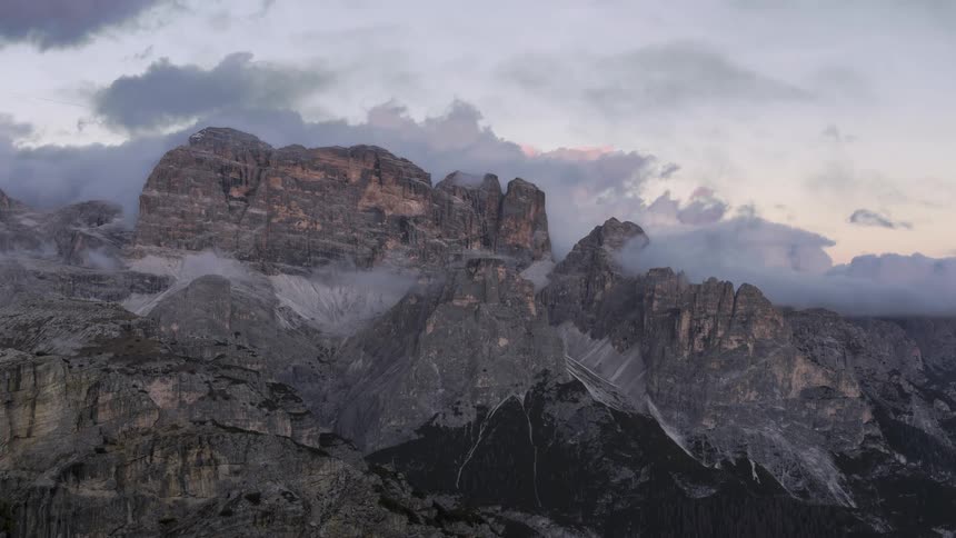 Dark clouds push into the sky over a giant mountain range