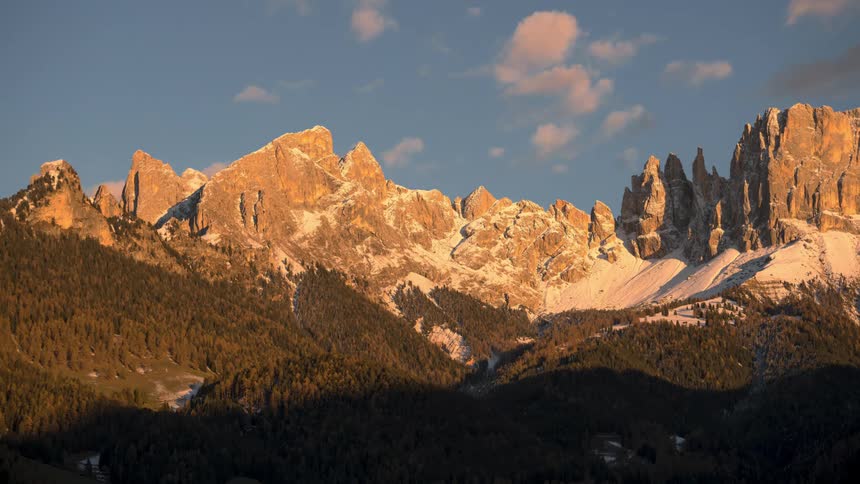 Snowy mountain range with a dusk day and clouds passing by