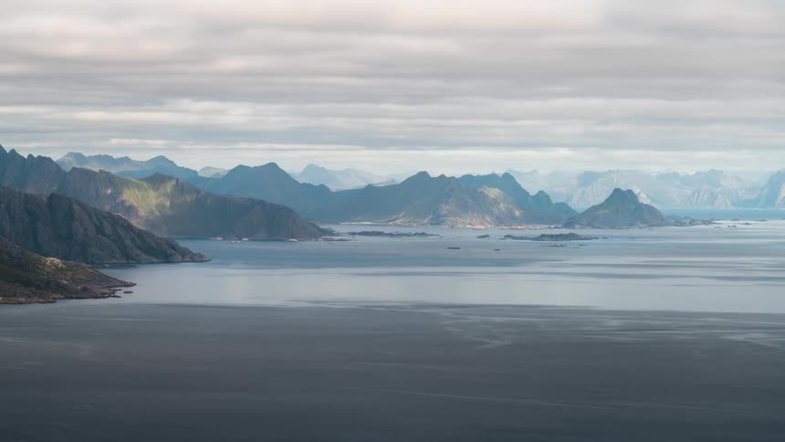 Rural communities on the shore of a lake next to giant mountain ranges
