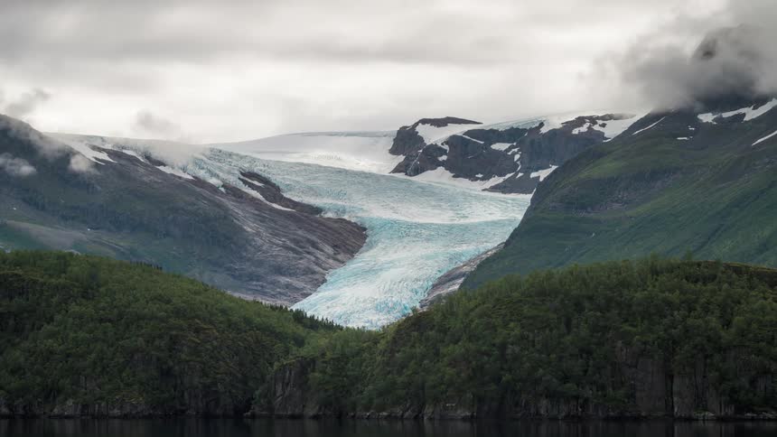 Landscape of mountains with glaciers by the sea with cloudy sky