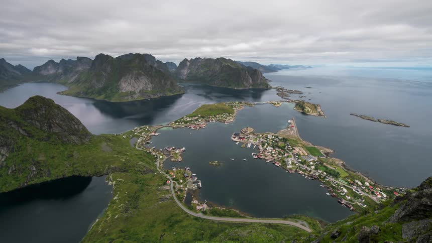 Aerial view of a coastal village highlighting a small coastal town surrounded by steep mountains and calm waters