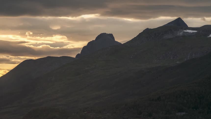 Mountainous landscape at dusk with cloudy sky