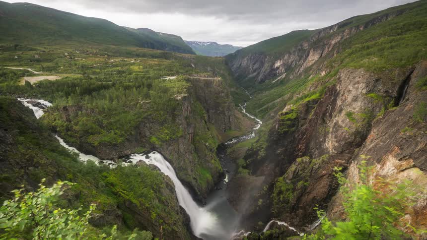 Mountainous landscape of a waterfall connecting to a river on a cloudy day