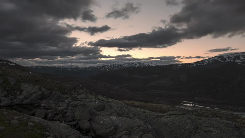 Black cloud landscape with darkening day above rocky mountains