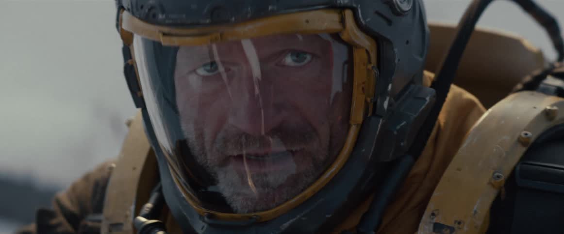 Man with scared facial expression wearing a helmet in a futuristic protective suit