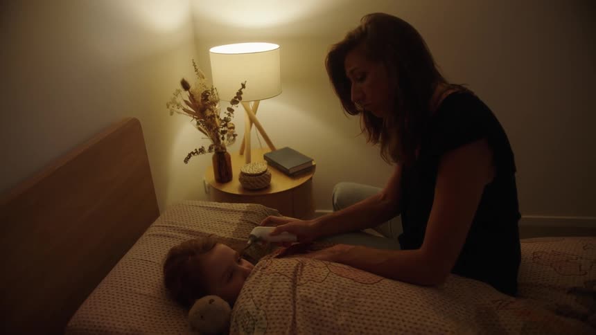 A mother takes her sick daughters temperature