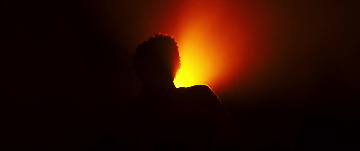 A silhouette of a persons profile against a vibrant orange and red background