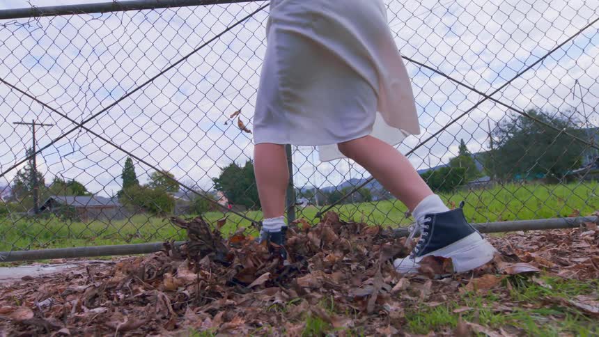 Womans legs dancing amid dry leaves