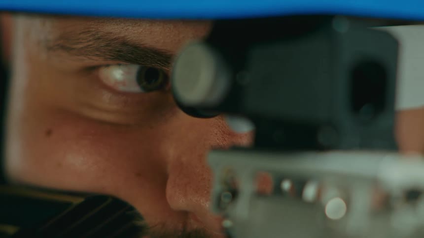 A man looks through a scope on a rifle