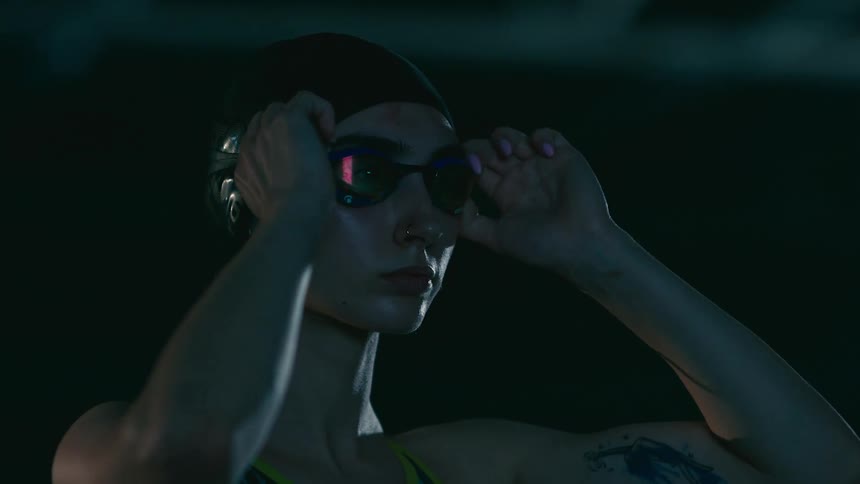 A female swimmer dons goggles