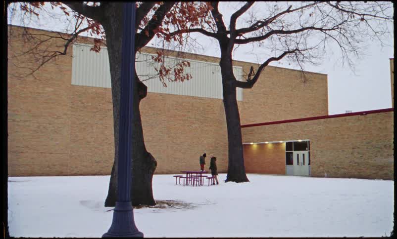 Child jumps off a picnic table at a school into their mothers arms