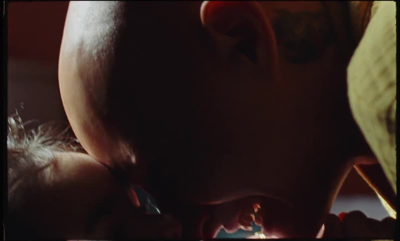 A bald woman playing with her daughter in the bedroom