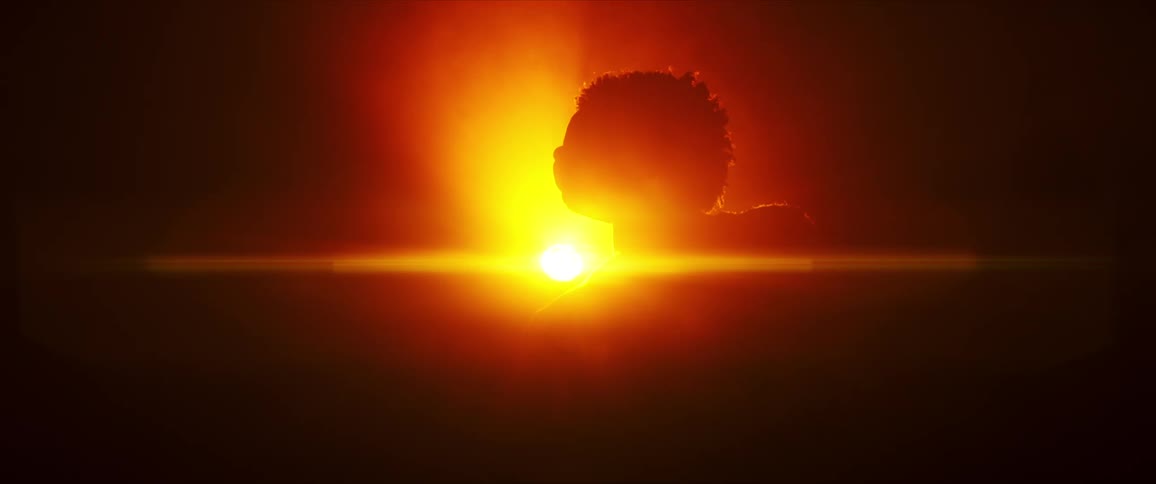 The sun is rising behind the person