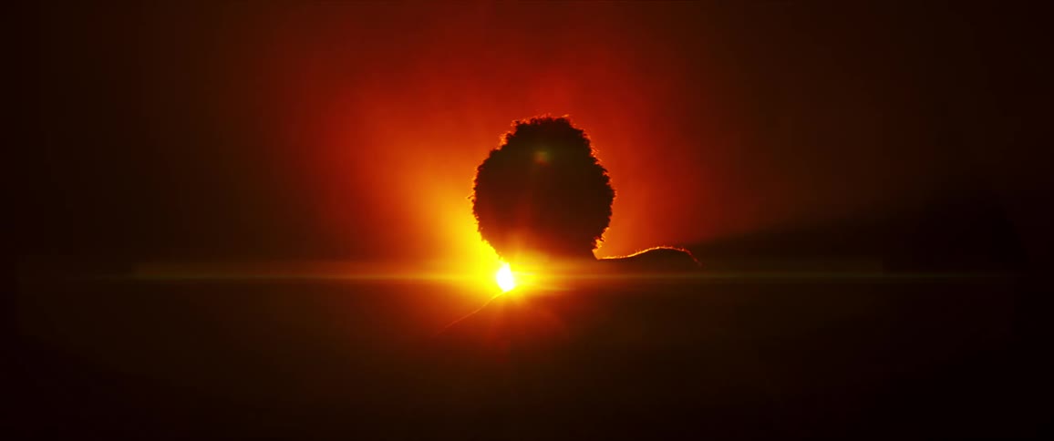 Silhouette of a person dancing against a bright yellow and orange halo of light