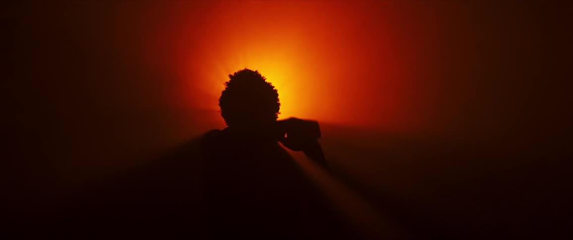 Silhouette of a person making body movements against a red light