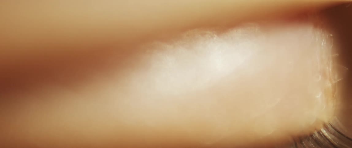 A closeup shows a person slowly opening and then closing their eyelid