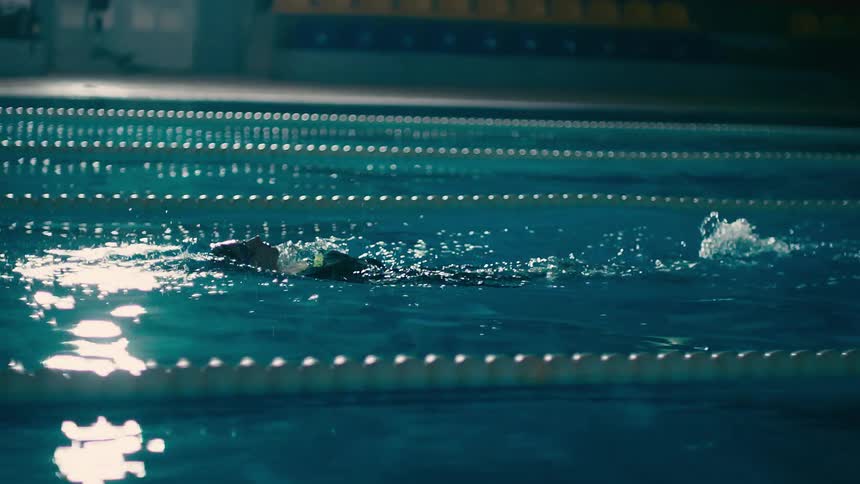 Person swimming backwards in a lane of a pool