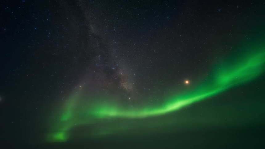 Aurora borealis flows across starry night sky