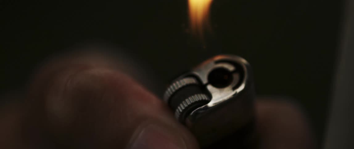 Closeup of a lit lighter with the flame visible at the top