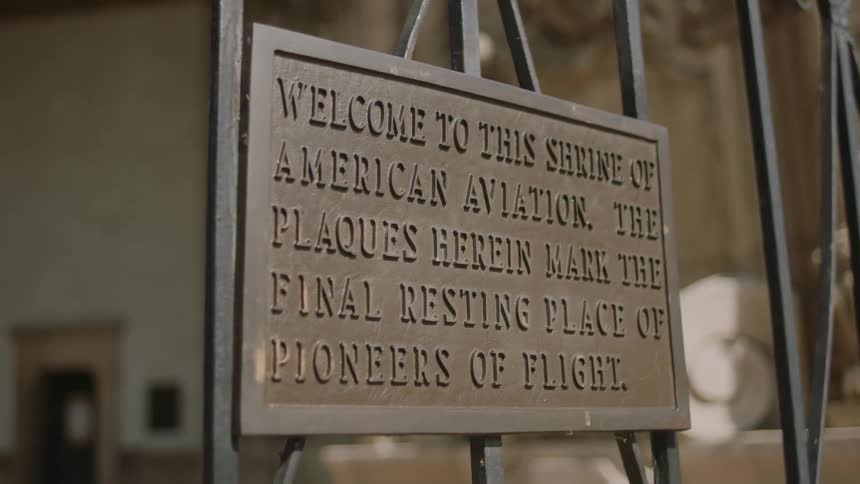 Bronze plaque welcoming you to shrine of american aviation on a wrought iron gate