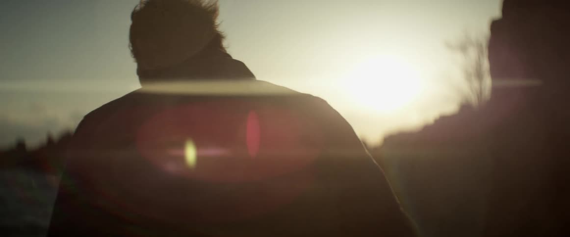 Two people near the water at dusk