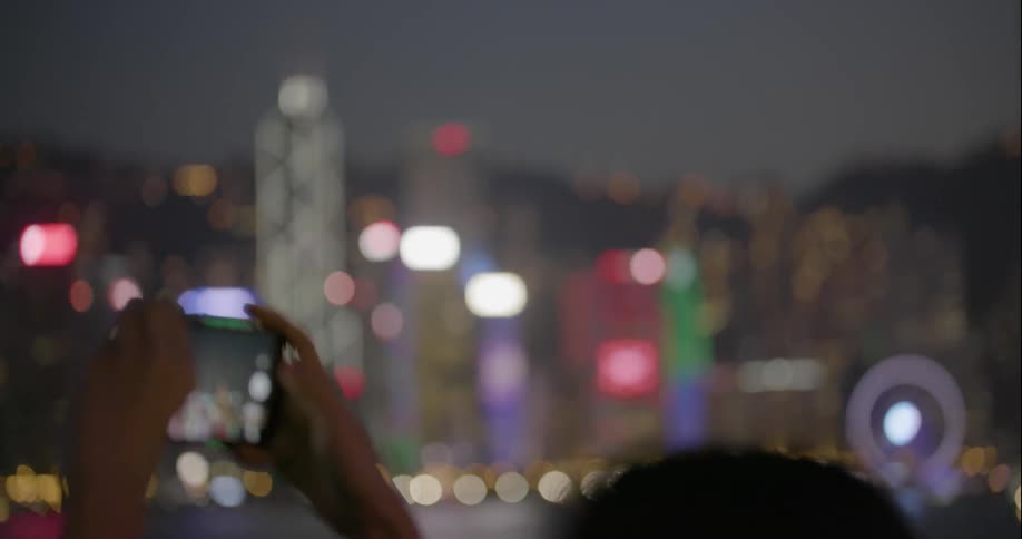 A person films the hong kong skyline on a cellphone