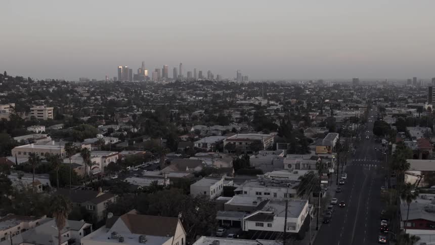 Aerial view of suburbs with a city's downtown in the far distance on a hazy day
