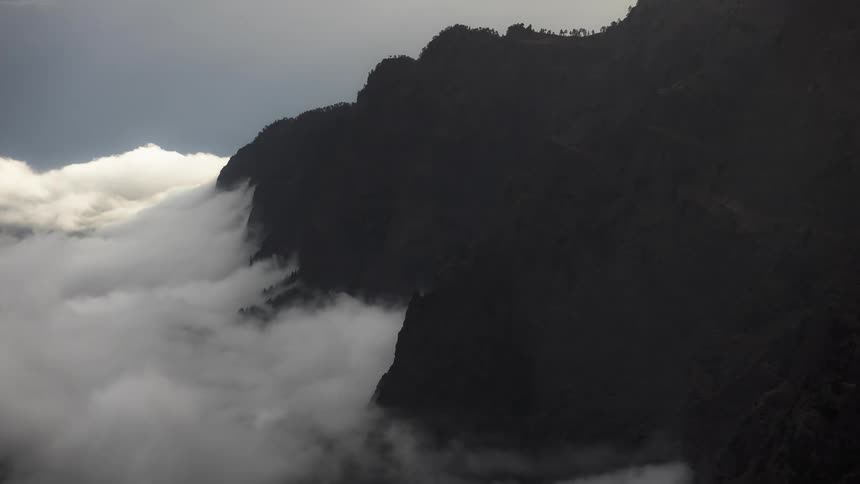Mountainous landscape with low clouds enveloping the slopes