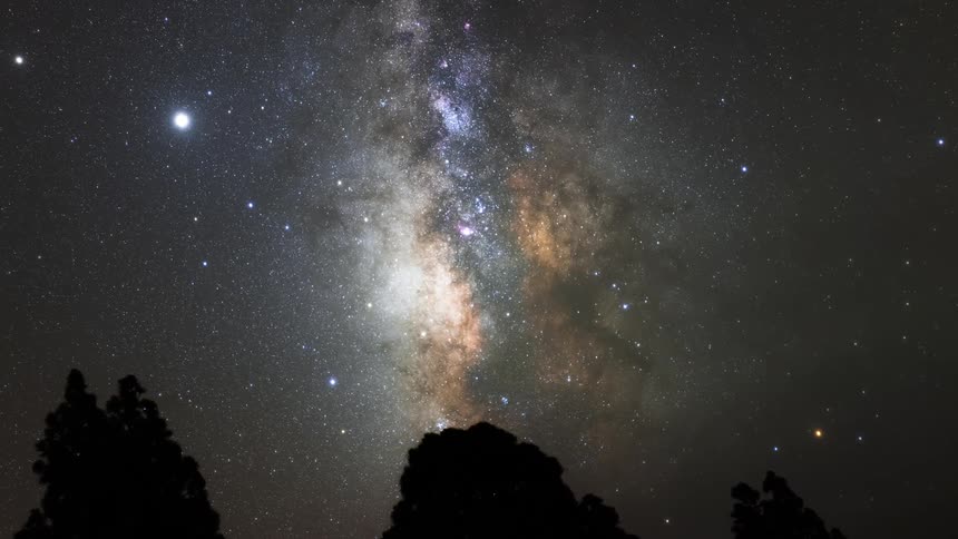Silhouette of rocks and a starry sky and celestial bodies