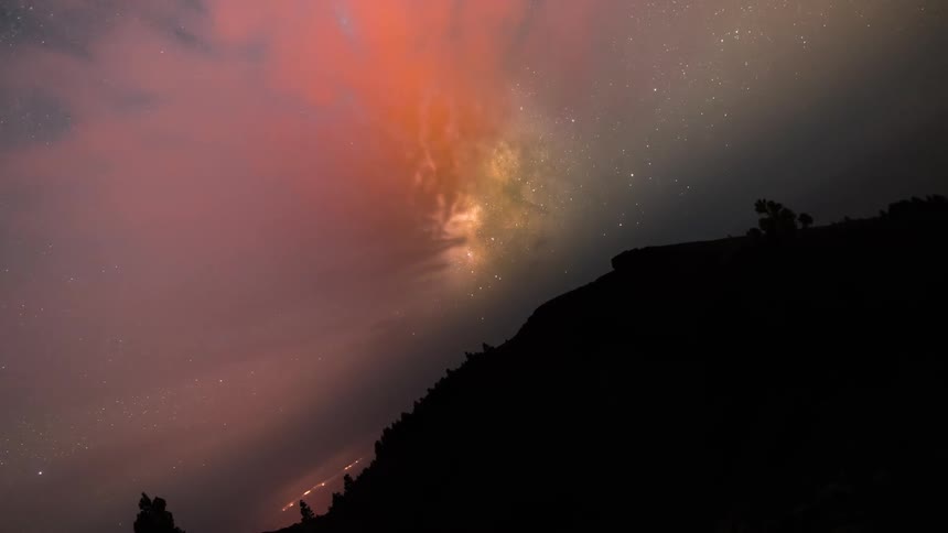 Night sky with stars and silhouette of mountains around