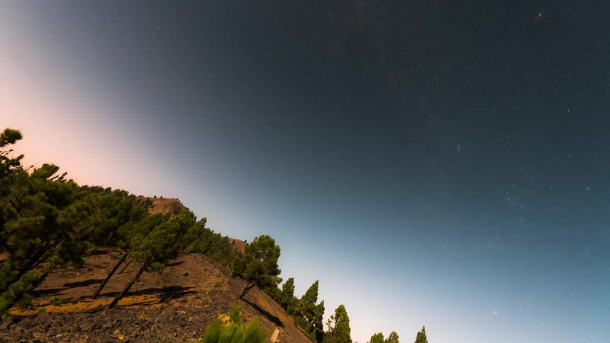 A view of a rural region where the movement is following the rotation of the earth and it is getting dark and the sky is becoming starry