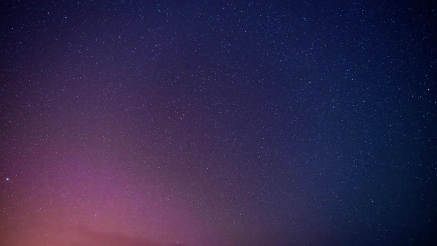 Clouds moving under the stars in a purple and blue sky