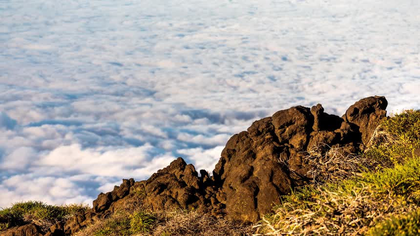 Rocky bed on a mountain with a sea of low white clouds