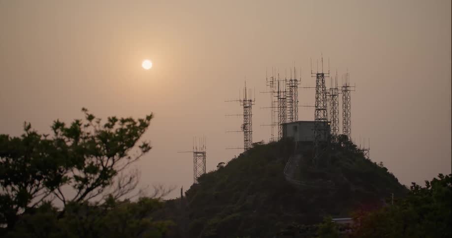 Radio towers hitting on a hill on a very hazy day
