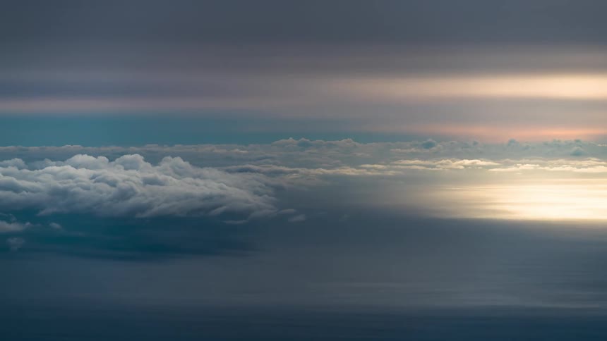 Setting sun shines through clouds in a red tinted sky