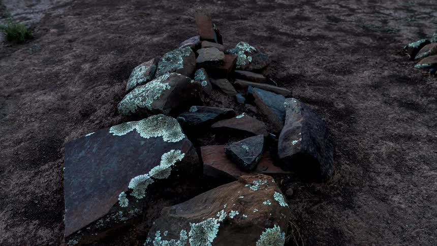 A makeshift fire pit made of varioussized rocks and flat stones
