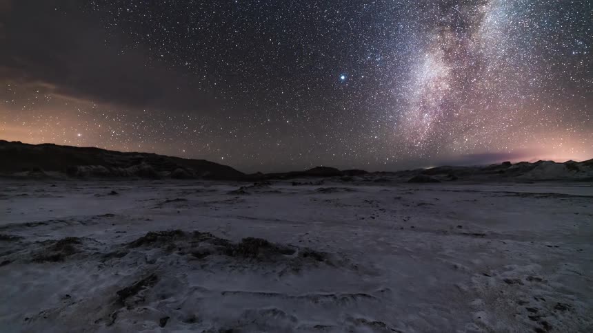 Time lapse of the milky way over a desert landscape at night