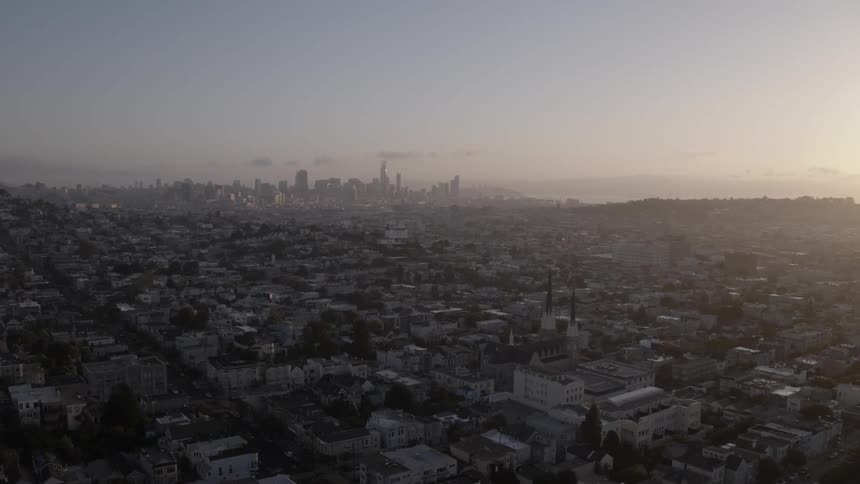 Suburbs of a large city seen at sunset with downtown in the distance