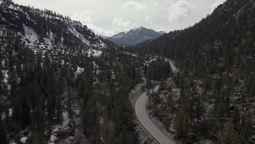 A car drives along a mountain road in the winter