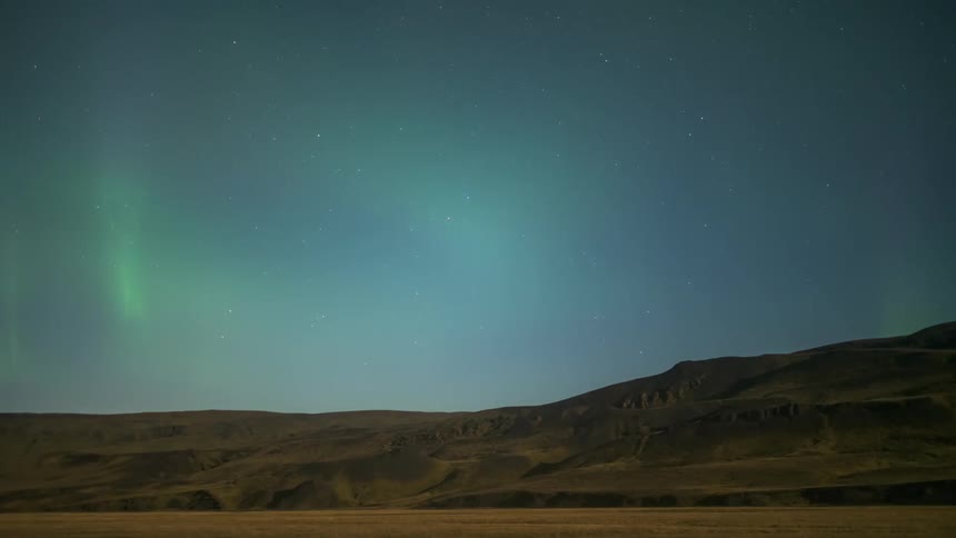 Sky with aurora borealis at night above mountains