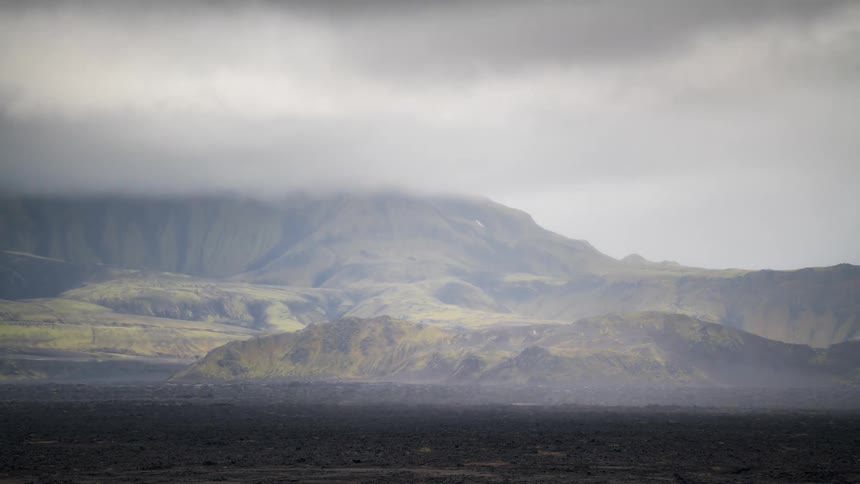 Time lapse of clouds rolling over a mountainous volcanic landscape