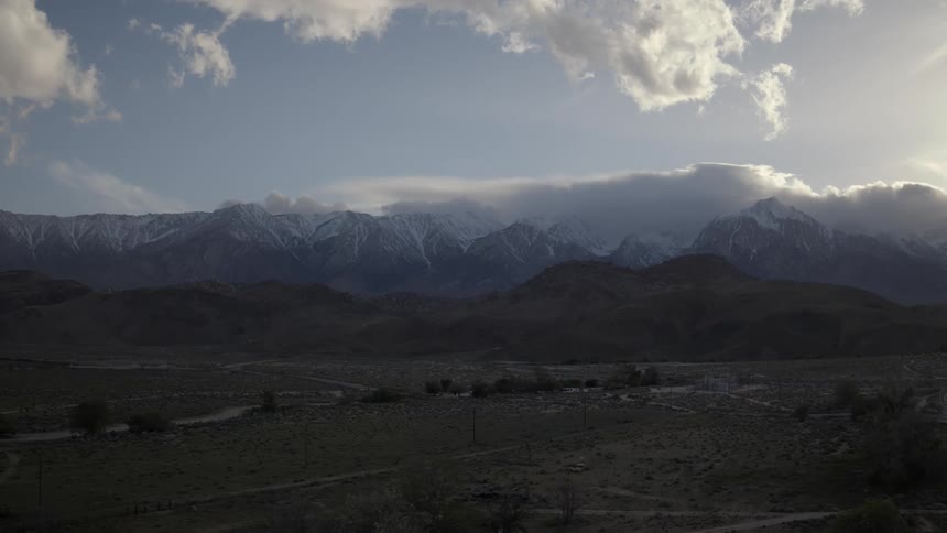 Mountain range partially covered in snow on cloudy day