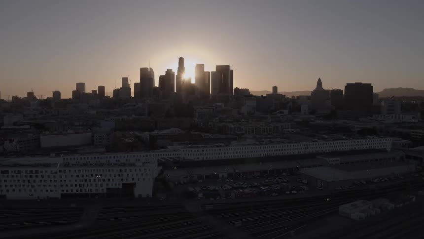 The sun hiding behind a city skyline