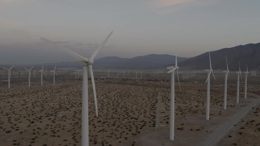 Wind turbines spin in a wind-farm in the desert