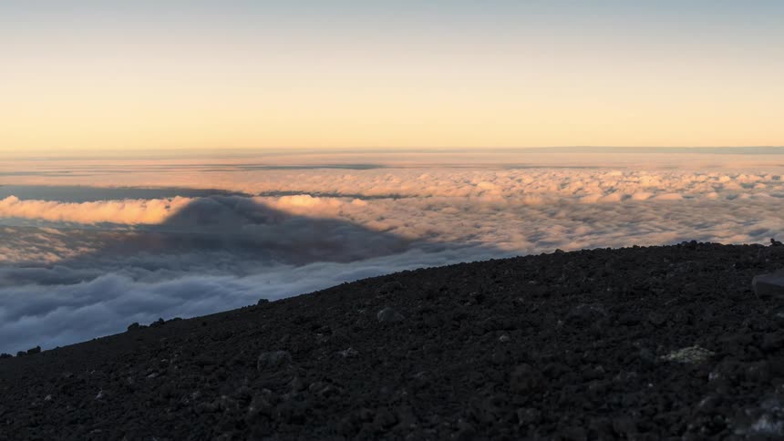 Landscape of stones on top of a mountain on the edge of a sea of clouds with a red sky